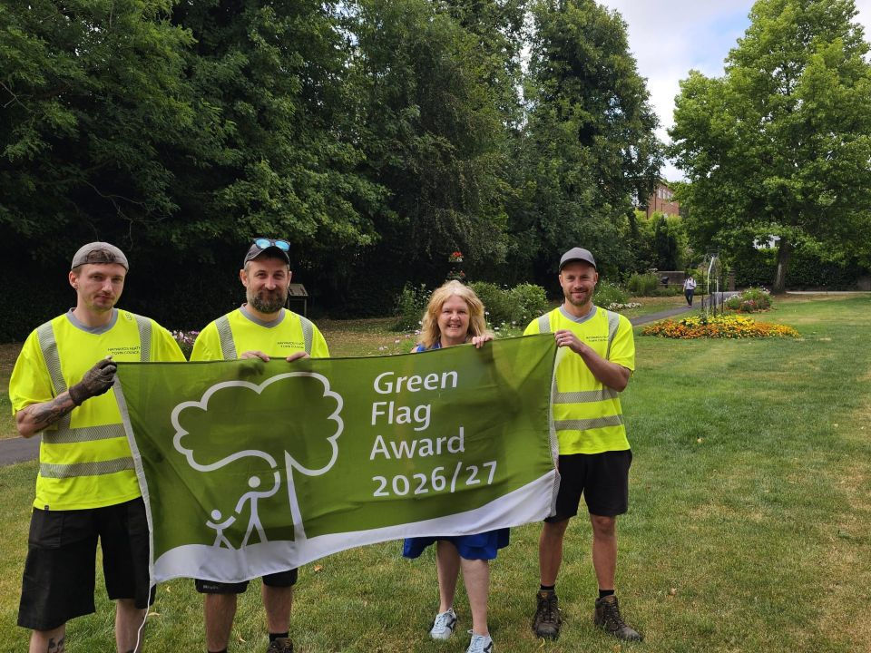 Groundstaff and Cllr Sandy Ellis holding the Green Flag Award on Muster Green