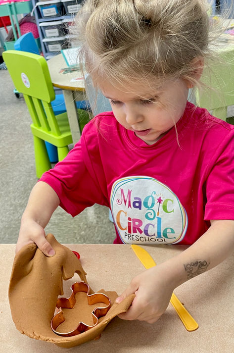 Magic Circle Preschool sensory table, little girl playing with gingerbread play dough making gingerbread menpeg