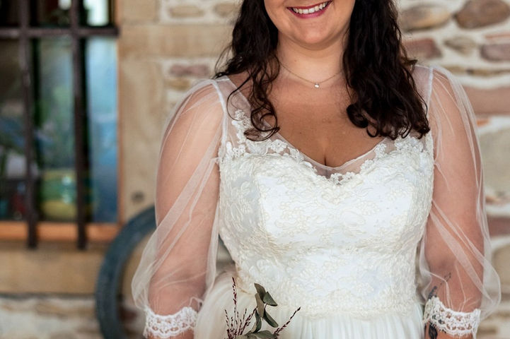 Future mariée dans la robe de mariage princesse romantique Iris, au bustier et manches 3/4 blousantes en dentelles et à la jupe en tulle fluide de la collection de tenues de mariage princesses de la créatrice Delphine Pinel dans les Monts du Lyonnais entre Lyon et Saint-Etienne