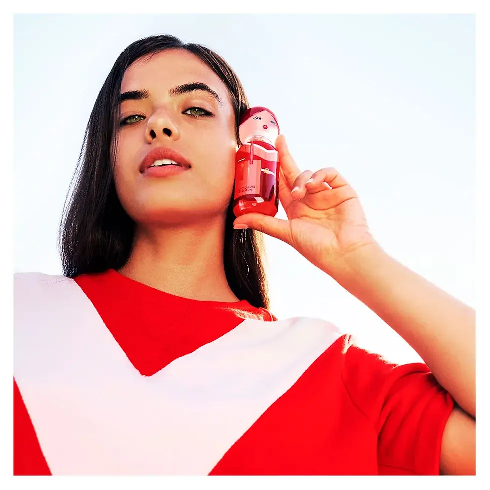 Miniatura: Mulher segurando frasco do perfume feminino United Colors of Benetton Sisterland Red Rose Eau de Toilette 80ml ao lado do ros