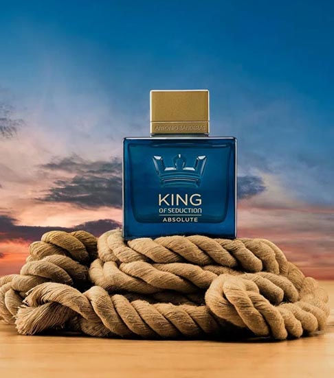 Miniatura: Frasco do perfume masculino King Seduction Absolute sobre cordas com o por do sol ao fundo
