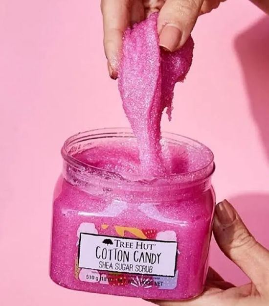 Miniatura: Mulher segurando o pote do esfoliante importado corporal com a tampa aberta e textura do produto nas mãos