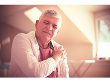 Man holding his shoulder due to joint pain.