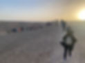 A line of people hiking in the desert