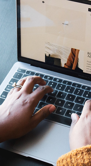 person using macbook pro on black table_