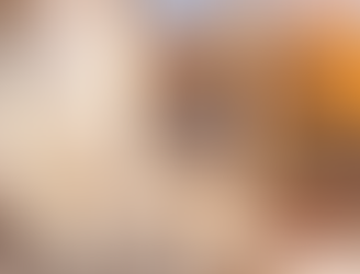 Warm afternoon light softening a cozy lounge with pillows and a blanket, creating a quiet, inviting atmosphere.