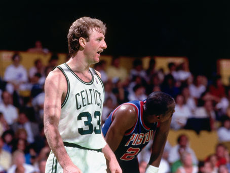 Larry Bird standing beside an opponent during an intense NBA game, representing the competitive culture and trash talk that became part of basketball history