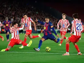 Raphinha attempts a shot under pressure from Atlético Madrid defenders during Barcelona’s 3–1 victory at Spotify Camp Nou.