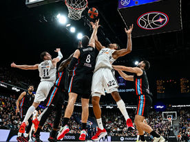 Real Madrid and Paris Basketball players contest a rebound during a EuroLeague game in Paris