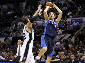 Dirk Nowitzki shooting a mid-range jumper over a defender during an NBA game with the Dallas Mavericks