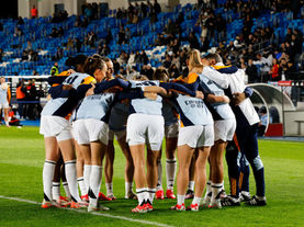 Real Madrid Femenino players in a team huddle before a match, highlighting women’s football at the club