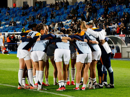 Real Madrid Femenino players in a team huddle before a match, highlighting women’s football at the club
