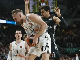 Real Madrid player drives to the basket while defended by a Paris Basketball player during a EuroLeague game