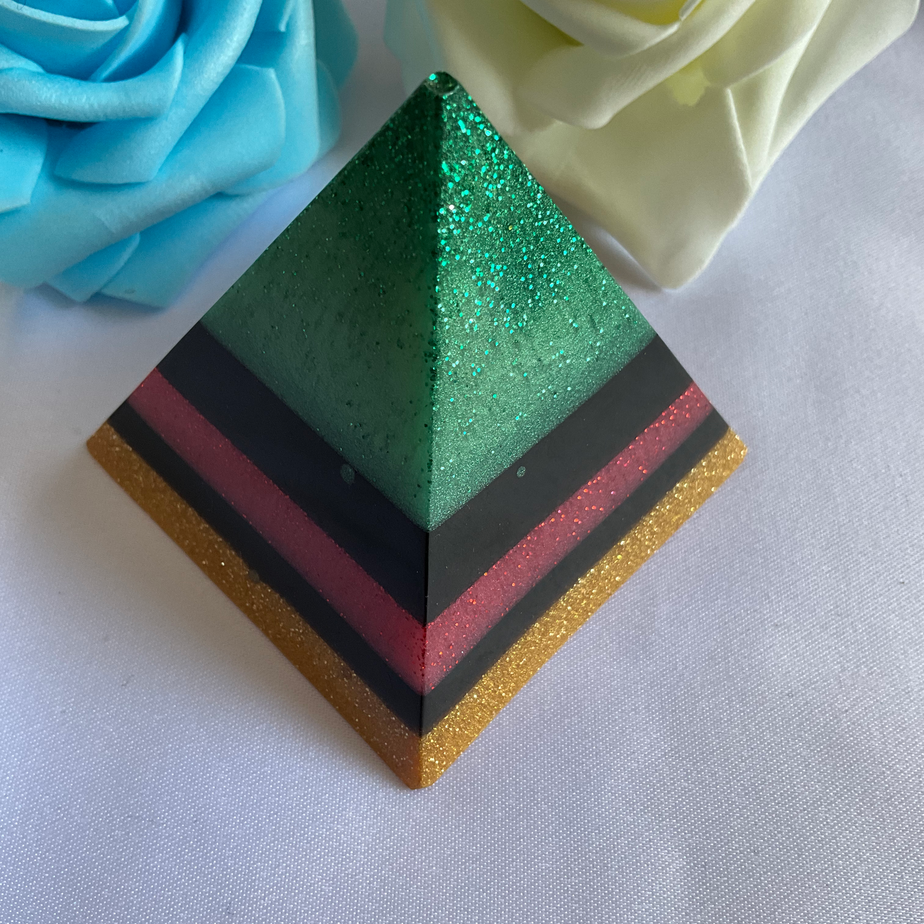 Green, red, black and gold resin pyramid