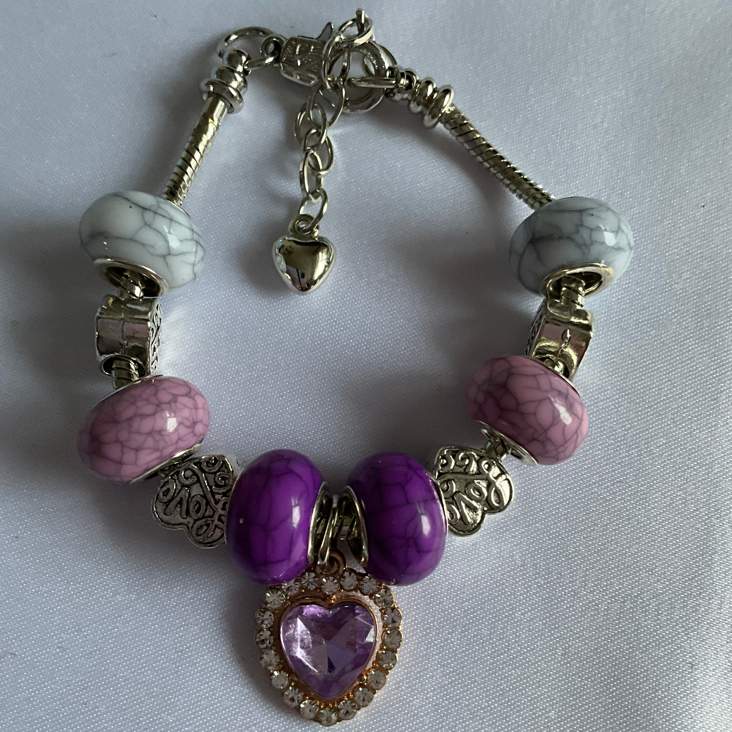Bracelet with light and dark pink beads with a gold plated metal chain