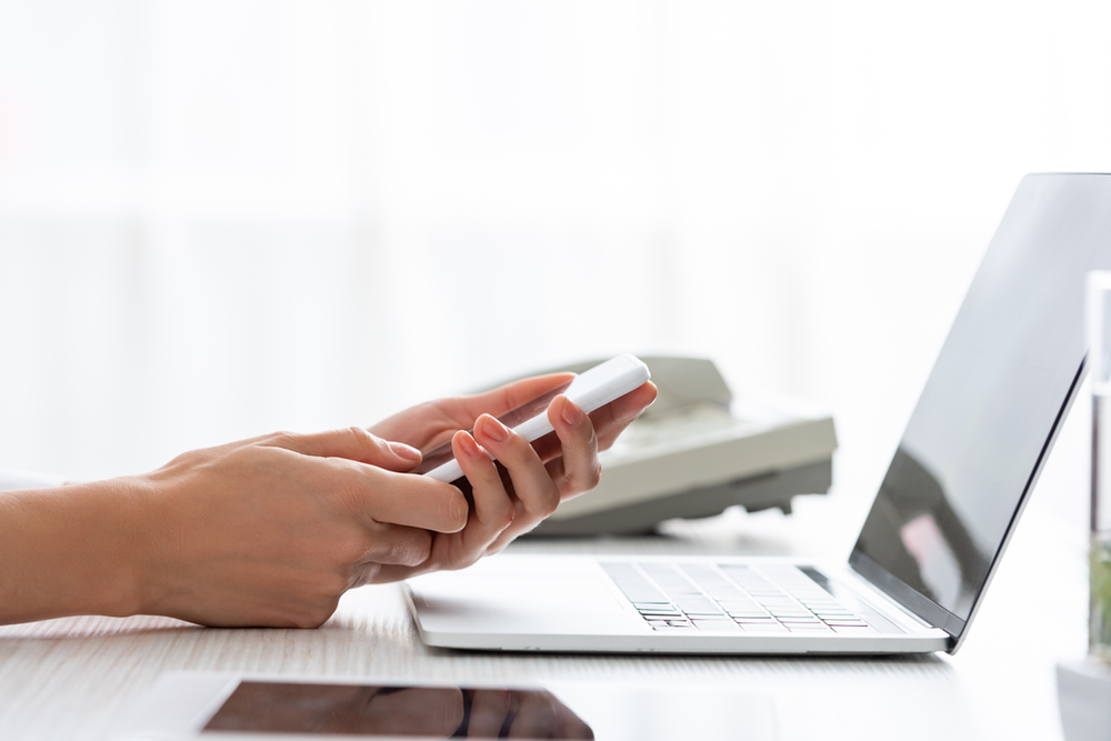 person tending to electronic devices (smartphone, tablet, laptop) to declutter their digital space