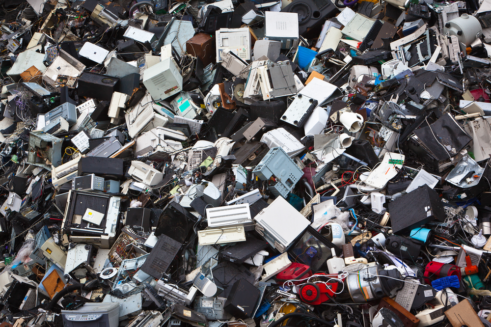 heap of e-waste garbage sitting in a landfill