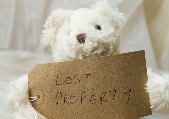 white teddy bear holding a tag that says, "Lost Property"