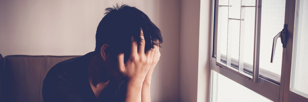 Young man showing distress with his head in his hands