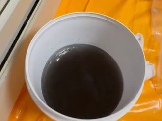 エアコンクリーニングで出た黒い水がバケツに入った写真。