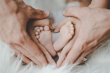 pieds bébé entourés des mains de père et mère