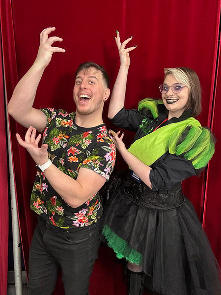 A person in a black shirt with puffy green sleeves (Remus Sanders cosplay) , standing next to Thomas Sanders