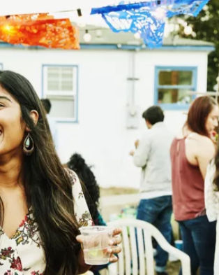 A joyful woman toasting with friends at her housewarming celebration