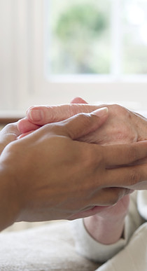 Caregiver holding elderly hands
