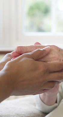 Caregiver holding elderly hands
