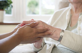 A woman and her carer hold hands