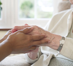 Cuidador segurando as mãos do idoso
