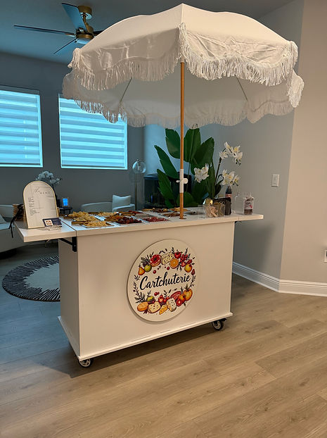 Custom Cartchuterie charcuterie cart set up for an event, featuring an elegant spread of meats, cheeses, fruits, and artisana
