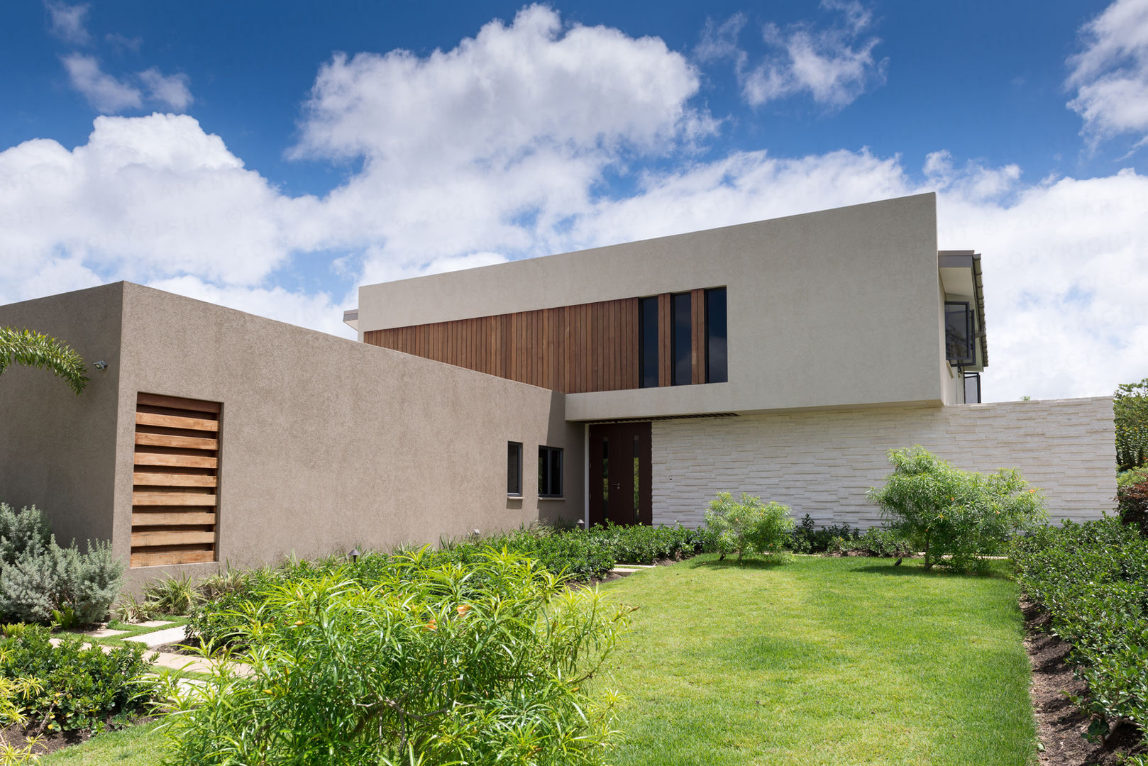 Carmel
Barbados
Volumes appear to slide past and over one another in the bold, kinetic architectural language used in our design for this stylish family home. The use of coral stone and timber cladding on walls grounds the modern design with reference to the Caribbean vernacular.
Doors that completely fold away and large windows merge outside with inside. The pool and garden are a constant on entering and while inhabiting the house.
Our environmentally conscious design facilitates through breeze which keeps the airy double height Great Room cool.