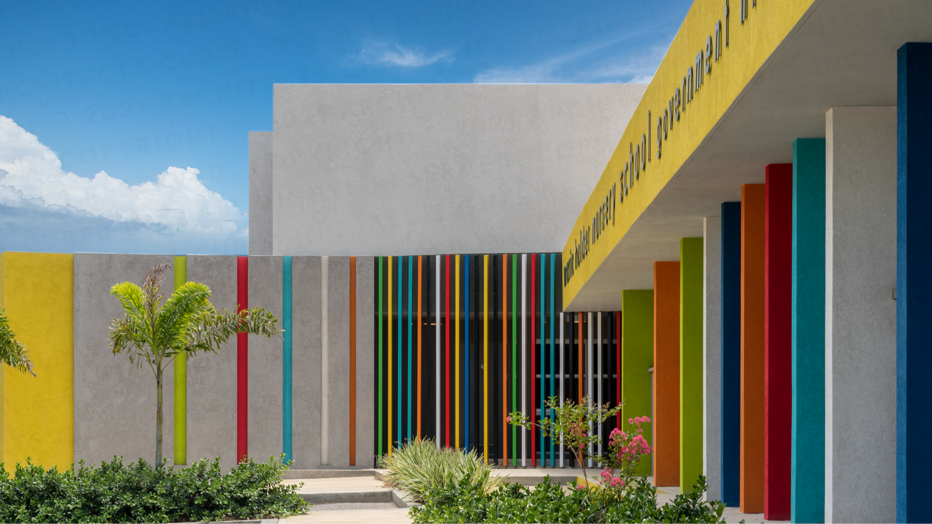 Maria Holder Nursery School
Government Hill
Barbados
The third school to be completed in the Maria Holder Memorial Trust nursery school series is this 120 pupil school for 3-5 year olds.
The school is located in an established school zone in-between an existing primary and secondary school. In harmony with these existing buildings the architecture of the nursery school borrows from their functional form with expressed columns and flat roofs.
Accessed form a secure garden, single bay classrooms promote breezy naturally ventilated learning spaces. Classrooms dialogue with each other and with the gardens through large openings and windows allowing transparency and reducing hidden spaces to promote child
security.
Maintaining the distinctive, colourful and contemporary brand aesthetic of the Maria Holder Memorial Trust’s nursery schools; the school’s architecture is both convivial and progressive and reflects our aim to provide a safe, child-centred environment where children want to be.