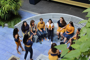 HEARTbeats members sitting in circular bench singing Red Desert