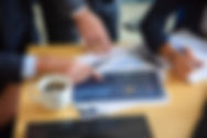 unrecognizable-businessman-pointing-printed-chart-showing-graph-colleagues-professional-co