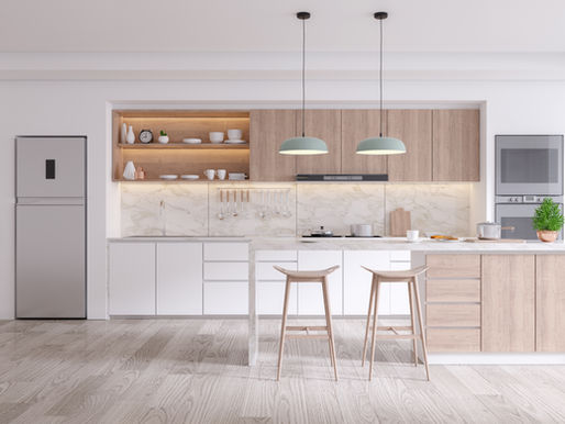 Modern kitchen with wooden cabinets, marble backsplash, and a large island with stools. Two pendant lights and a potted plant add style.