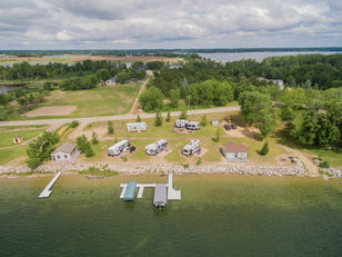 Drone view of resort, RV campground, softfball field, and cabins near lakeshore