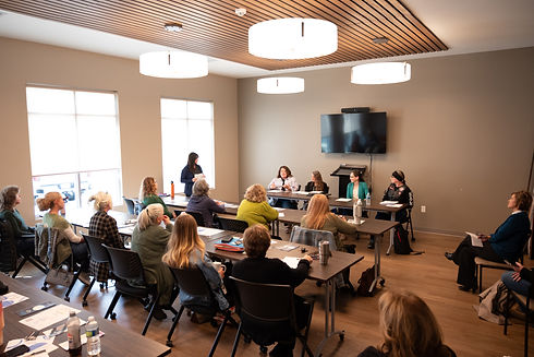 Attendees in a modern conference room with a panel