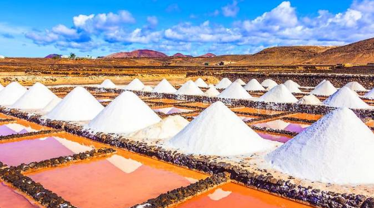 The Salinas de Janubio and piles of coral-colored salt at sunset