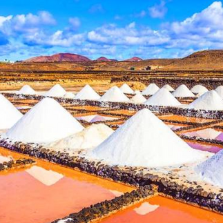 The Salinas de Janubio and piles of coral-colored salt at sunset