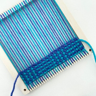 weaving on a tabbyandtweed square frame loom using blue and turquoise yarn