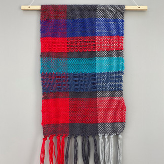 Handwoven wall hanging in red and blue and grey shades