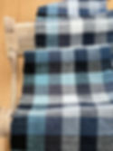 Thumbnail: wooden rigid heddle weaving loom with a blue and grey checked weave on it