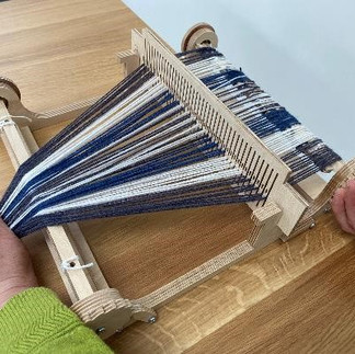 warping a rigid heddle loom with blue and white yarn