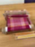 rigid heddle loom with a pink, orange and yellow houndstooth weave on it
