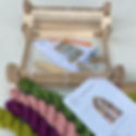 Wooden weaving loom kit with colorful yarns in green, pink, and purple. Assembly instructions and diagram are visible in the background.