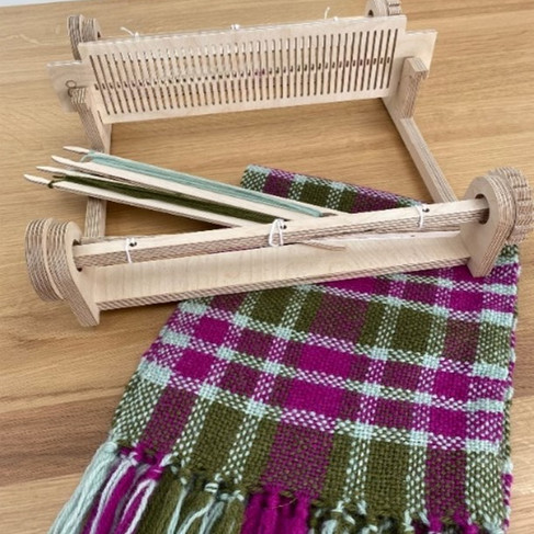 rigid heddle weaving loom kit showing a pink and green scarf woven on the loom