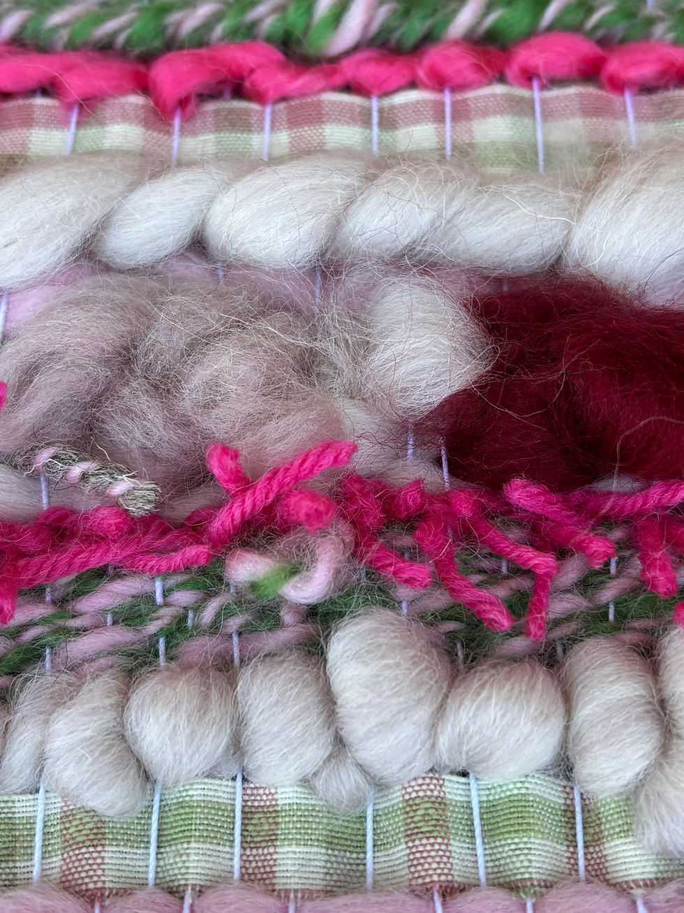 Close-up of woven textile with pink, green, and cream yarns. Features fluffy textures and checkered pattern, creating a cozy, handmade feel.