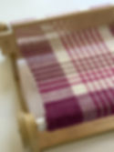 pink and white patterned weave on a wooden rigid heddle weaving loom